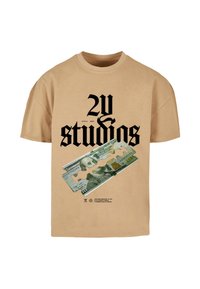 Kremskrāsas kokvilnas T-krekls ar melnu tekstu "2V studios" un grafiku ar dolāru banknoti, pāri kurai novietota skuvekļa asmens.