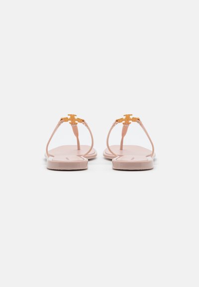 Pink flat sandals with slim straps, gold-tone hardware, and a flat rubber sole. Smooth texture, minimalistic design, and open-toe style.
