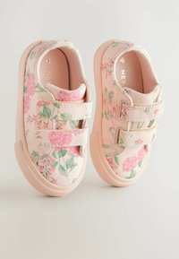 Rosa blommiga canvas sneakers med kardborreband, med en texturerad sula och ett botaniskt mönster av rosor och gröna löv.