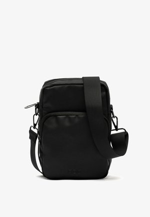 Sac à bandoulière rectangulaire noir en nylon texturé, doté d'une longue sangle réglable et d'une poche zippée à l'avant.