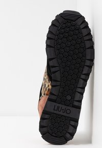 Svart gummisula med mönstrat grepp; ovansidan har leopardmönster, svart mocka och rosa detaljer. Logotypen "LIU JO" präglad på sidan.