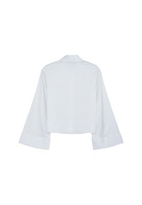 Camicia bianca a maniche lunghe cropped con ampi polsini e un colletto piccolo, esposta piatta su uno sfondo bianco.
