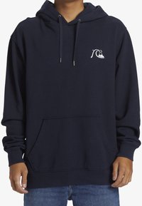 Sudadera azul marino con capucha con cordón, bolsillo delantero y gráfico de una ola blanca en el lado izquierdo del pecho. Textura suave y puños acanalados.