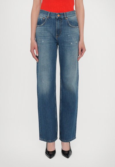 Lichtblauwe hoge taille rechte jeans met front pockets, subtiele vervaging en versleten details, gecombineerd met zwarte puntige hakken.