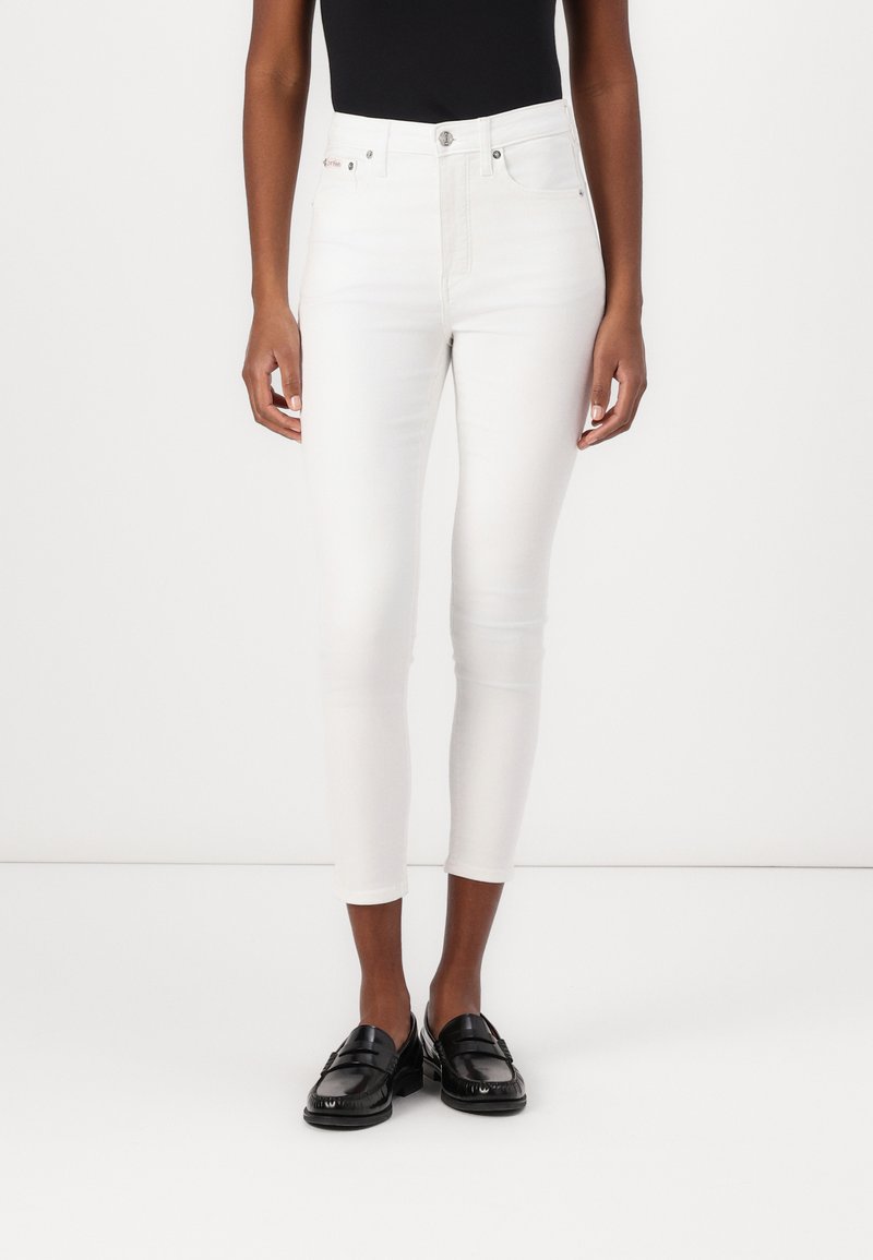 Witte skinny jeans met vijf-pocket ontwerp, metalen knoop en rits sluiting, en subtiele stretch. Gecombineerd met zwarte instappers.