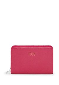 Cartera de cuero rosa con cierre de cremallera, que presenta una textura suave y el logo grabado "TOUS" en la parte frontal.