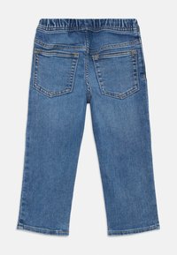 Vue arrière d'un jean en denim bleu de taille enfant avec une taille élastique et deux poches arrière, posé à plat sur un fond blanc.