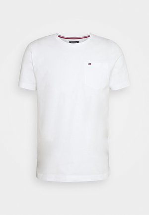 Camiseta blanca de algodón con mangas cortas, cuello redondo y un bolsillo en el pecho izquierdo con un pequeño logotipo. Textura suave.