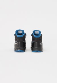 Zapatos de senderismo negros con acentos azules, con un diseño de caña alta, parte superior de nailon texturizado, suelas de goma y marcados con "Salomon" a los lados.
