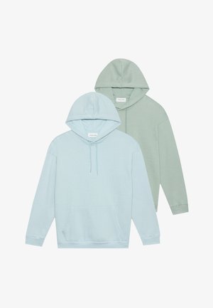 Du trijų kapučino megztinių, šviesiai mėlynos ir švelnios žalios spalvos, pagaminti iš tekstūruotos medžiagos. Kiekvienas turi priekinę kišenę ir šonkaudžius rankogaliuose.