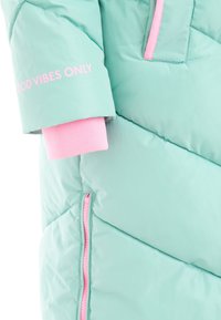 Mintgrün gepolsterte Jacke mit ärmellangem Schnitt, pinkem Bündchen, pinkem Reißverschluss und dem Text "GOOD VIBES ONLY" in Pink auf dem Arm.