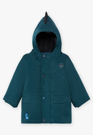 Veste sarcelle à capuche, avec une finition texturée, des boutons-pression, des poches plaquées frontales et un motif de dinosaure bleu sur le côté.