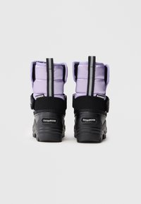 Bottes imperméables violettes avec une semelle texturée noire et une sangle ajustable. Tige rembourrée avec des coutures verticales, talon renforcé et détail de logo.