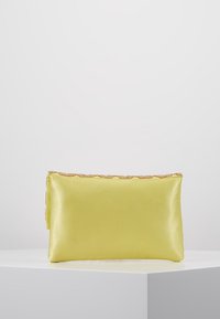 Žlutá saténová kabelka na ruku s hladkým povrchem, obdélníkovým tvarem a korálkovým lemem podél horního okraje. Rozměry přibližně 25 cm na 15 cm.