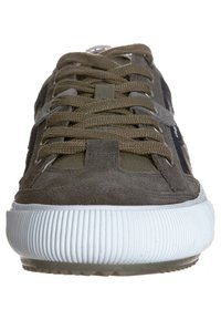 Baskets en daim vert olive avec une semelle en caoutchouc blanche à rainures et des lacets assortis ; elles présentent un panneau en tissu texturé et un logo détaillé sur le côté.