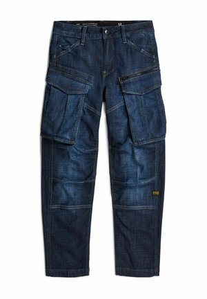 Donkerblauwe denim cargobroek met meerdere grote zijzakken, vooraan ritssluiting en knoopsluiting, en een klein merklabel vlak bij de zoom aan één been.