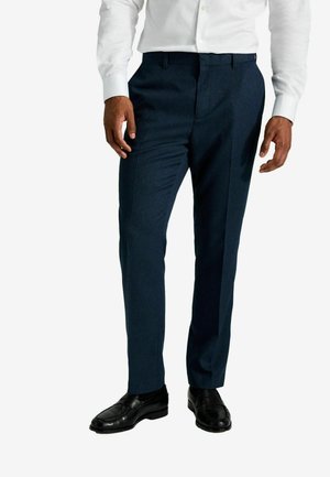 Navy blue dress pants with a textured fabric, slim fit, featuring front crease and side pockets, paired with black dress shoes.