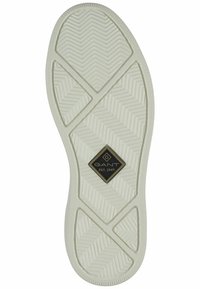 Suola bianca in gomma con motivo a spina di pesce, con un logo a diamante nero e oro al centro. Bordi testurizzati per una migliore presa.