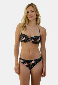 Ensemble de bikini à motifs floraux, avec un fond noir et des motifs floraux roses et verts. Le haut présente un détail twist ; le bas est de coupe classique.