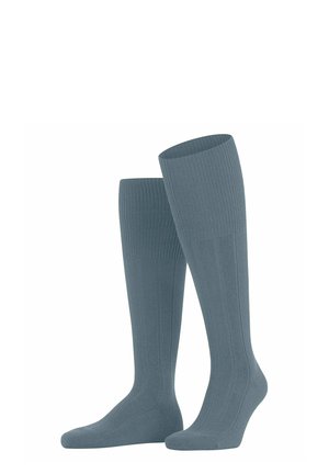 Chaussettes montantes jusqu'au genou de couleur bleue douce avec une texture lisse et un dessin côtelé vertical, avec un renfort à l'orteil et un soutien de la voûte plantaire.