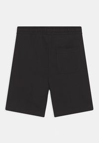 Svarta shorts med elastisk midja och en enda bakficka på högra sidan, lagda platt på en vit bakgrund.