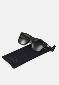Fekete napszemüveg, matt felülettel, négyzet alakú kerettel, sötét gradiens lencsékkel és fém részletekkel. Tartalmaz egy fekete puha tasakot logóval.