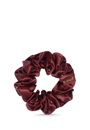 Bordeaux satijnen scrunchie met kleine kraaltjes en een gouden "lesilqué" label op gladde stof.