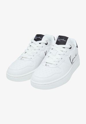 Hvide lædersneakers med en glat overflade, perforeret tåbokse, snørebåndslukning og sorte detaljer på tungen med et signaturdesign.