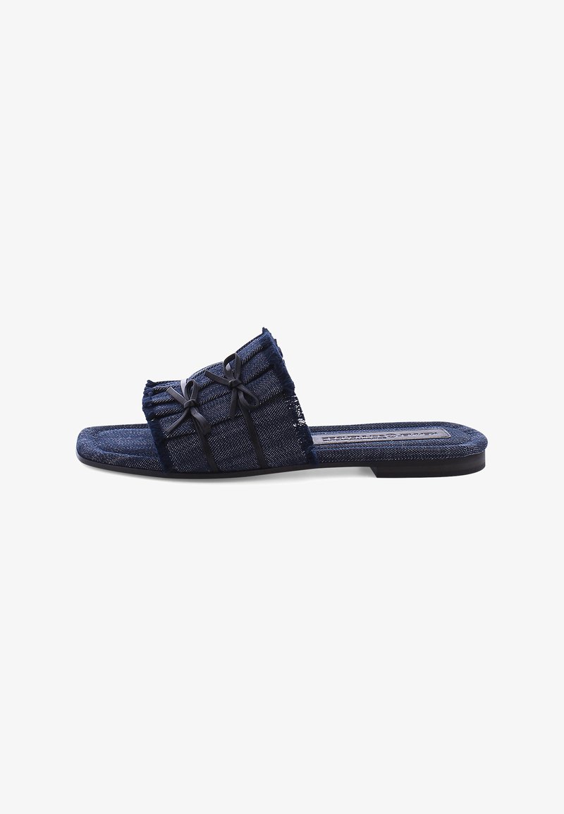 Denim slide sandals in dark blue with frayed edges. Features three black bows and flat soles. Simple, open design for easy wear.