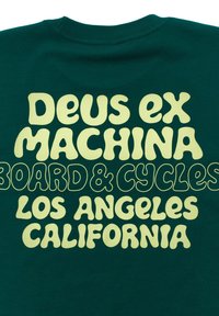 Green cotton t-shirt featuring large, playful yellow text. Text includes "Deus ex Machina," "Board & Cycles," and "Los Angeles, California."