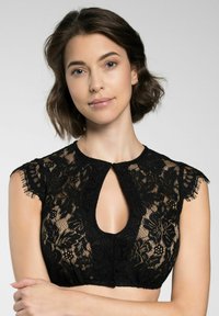 Schwarzes Spitzen-Crop-Top mit Schlüssel-Ausschnitt, gewellten Cap-Ärmeln, floralen Mustern und Knopfverschluss an der Vorderseite.
