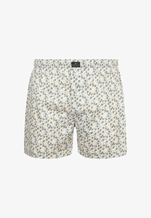 Witte boxershorts met een klein blauw en geel bloemmotief en een elastische tailleband met een zwart merklabel aan de voorzijde in het midden.