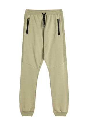 Joggers de un suave color verde oliva claro con perneras ajustadas, cinturilla elástica, cordón y dos bolsillos laterales con cremallera. Textura de tela suave y lisa.