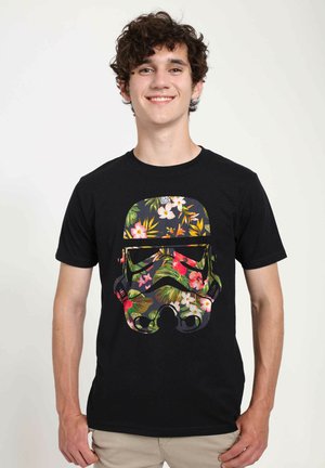 Schwarzes Baumwoll-T-Shirt mit einem bunten Blumenmuster in Form eines Stormtrooper-Helms. Kurze Ärmel und Rundhalsausschnitt.