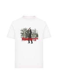 White cotton t-shirt featuring a black graphic of a figure wielding a weapon, with a cabin and trees, and "FRIDAY THE 13TH" in red text.