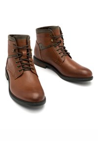 Brązowe skórzane botki za kostkę z okrągłymi noskami, sznurowanym designem, kontrastowymi brązowymi akcentami i fakturowaną powierzchnią. Czarne gumowe podeszwy.