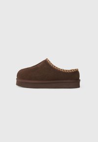 Brune ruskinds slippers med en afrundet form, der har en flettet tekstilaccent langs den øverste kant og en tekstureret gummisål.