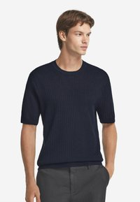 Marinblå ribbad kortärmad stickad tröja med rund halsringning, med en figurnära silhuett och textilstruktur för extra dimension.