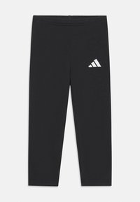 Czarne legginsy wykonane z elastycznego materiału. Posiadają elastyczny pas i biały logo Adidas po lewej stronie. Gładka struktura.
