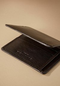 Brown leather wallet with an open flap, featuring card slots and a textured surface. Notable stitching detail along the edges.