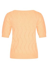 Persikka neulepaita lyhyillä hihoilla, jossa on aaltoileva kuvio ja kohokuviot. Ribattu kaula-aukko ja helma lisäävät tekstuuria.