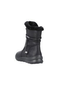 Bottes noires en cuir jusqu'à la cheville avec une doublure douce en fourrure noire, une finition texturée, un cordon de serrage ajustable et une semelle en caoutchouc crantée.