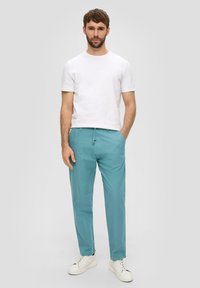 Lichtblauwe casual broeken met een ontspannen pasvorm, gecombineerd met een effen witte crew neck t-shirt en witte sneakers. Soepele textielafwerking.