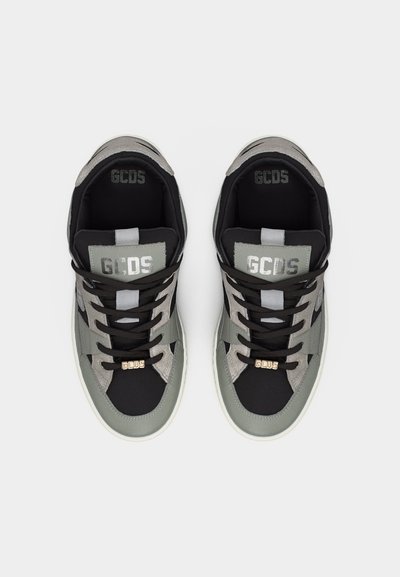 Ζευγάρι γκρι και μαύρα αθλητικά παπούτσια GCDS με μαύρα κορδόνια και ασημένιες λεπτομέρειες λογότυπου, φωτογραφημένα από πάνω σε λευκό φόντο.