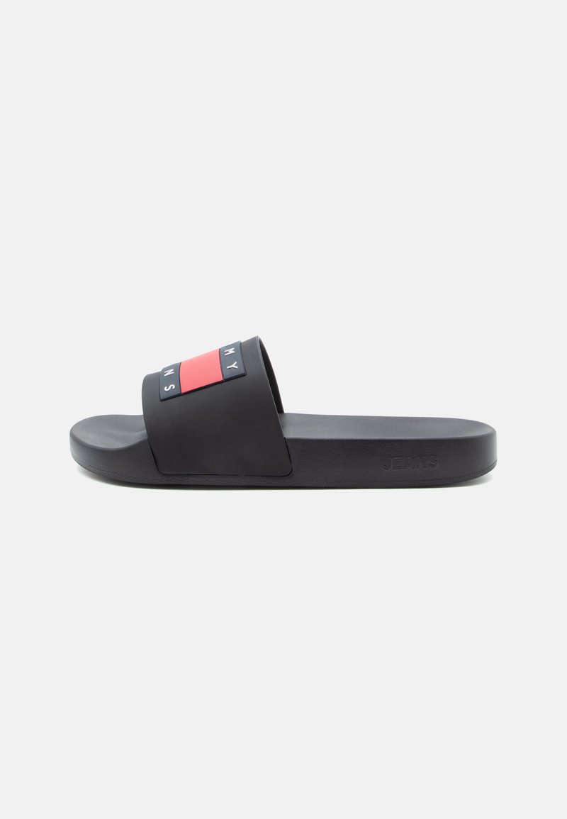 Black rubber slide sandal featuring a wide strap with a red and black graphic design, and embossed text. Text reads "MY JEANS."
