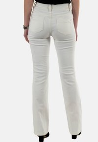 Jeans blancs évasés avec une texture lisse, taille haute et deux poches arrière. Finitions avec des accents de coutures et un léger stretch.