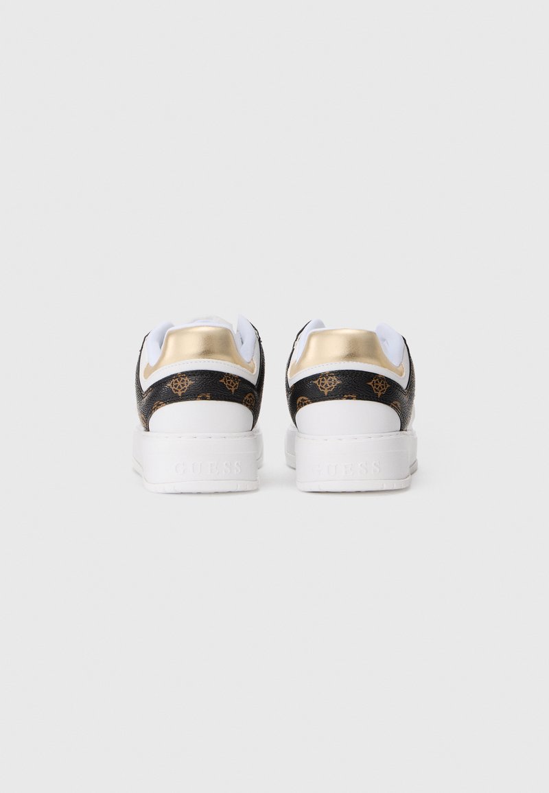 Een paar witte sneakers met zwart en bruin gepatterneerde accenten en gouden hieltabs, bekeken van achteren op een effen achtergrond.