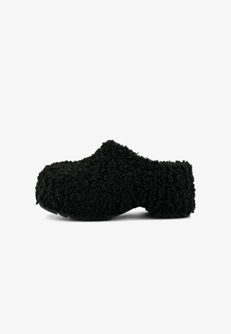 Crne klompe obložene flisom s zaobljenim vrhom, teksturiranom površinom i ravnim potplatom. Imaju dizajn koji se lako obuva.