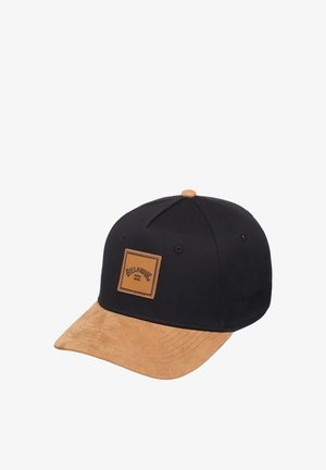 Sort baseball cap med en tan ruskindsbrim, der har et firkantet læderpatch med prægget logo og en stofknap på toppen.