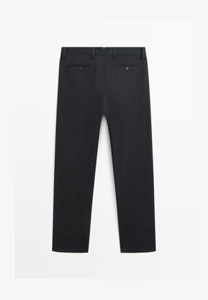 Pantaloni formali neri mostrati da dietro con passanti per cintura, due tasche posteriori con bottoni e una linea dritta delle gambe.